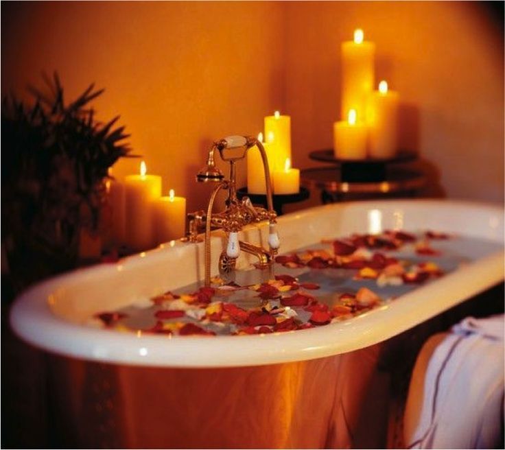 ρομαντική ατμόσφαιρα στο μπάνιο με κεριά και ροδοπέταλα
